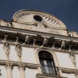 Nel piano d�attico alle semicolonne si sostituiscono paraste con figure scolpite di angeli e le mensole sotto il cornicione diventano fiere aquile di pietra dalle ali spiegate. A coronare la composizione si trova una sorta di timpano semicircolare centrale decorato a conchiglia (foto di Nicola Imperiale)